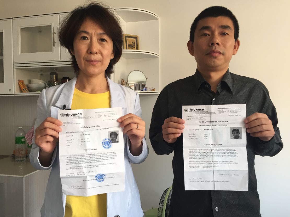 Chinese dissidents Yu Yanhua, left, and Yan Bojun pose with their U.N. asylum  seeker documents from the UNHCR in Bangkok. They fled China together for safety in Thailand but now fear their government will come after them even outside of its borders.