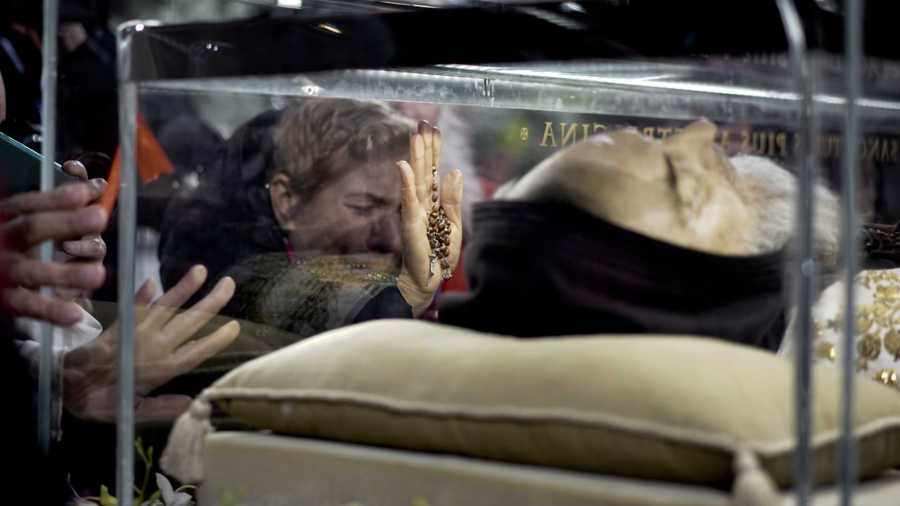A woman cries Wednesday, February 3, as she touches the box containing the remains of St. Pio of Pietrelcina. The body of the Catholic monk, who died in 1968, was displayed in Rome's San Lorenzo Basilica.