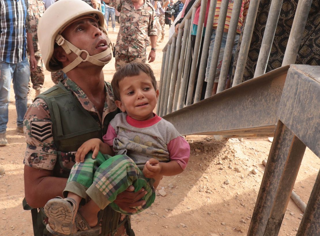 A Jordanian soldier carries a Syrian refugee at the al-Roqban makeshift camp, on the border with Syria, in September.