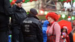 A woman in fancy dress speaks to the police as she takes part in Cologne's annual Carnival celebration.