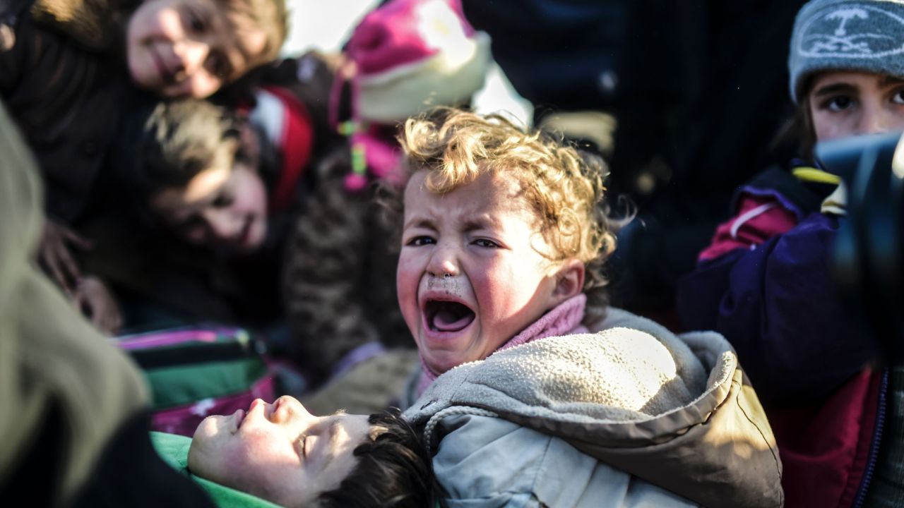 A Syrian child is carried out of the embattled city of Aleppo in February as residents fled the city following air strikes.