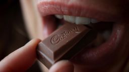 BRISTOL, ENGLAND - JANUARY 19:  In this photograph illustration a woman eats a chunk of chocolate from a bar of Cadbury's Dairy Milk chocolate on January 19, 2010 in Bristol, England. The US food giant Kraft has today agreed a takeover of Dairy Milk maker Cadbury in a deal worth 11 billion GBP, however many Cadbury workers remained concerned over the longterm future of their jobs.  (Photo by Matt Cardy/Getty Images)