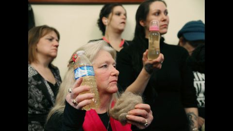 Flint, Michigan, residents Gladyes Williamson, center, and Jessica Owens, right, attend the House Committee on Oversight and Government Reform hearing on Capitol Hill about the Flint <a href="http://www.cnn.com/2016/02/03/us/flint-michigan-water-crisis/" target="_blank">water crisis</a>. Williamson and Owens hold bottles of contaminated water, and Williamson shows a clump of her hair. The two traveled to Washington by bus with other families to demand that Gov. Rick Snyder be brought to testify before Congress. The House hearing was on Wednesday, February 3. 
