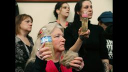WASHINGTON, DC - FEBRUARY 03: Flint residents Gladyes Williamson (C) holds a bottle full of contaminated water, and a clump of her hair, alongside Jessica Owens (R), holding a baby bottle full of contaminated water, during a news conference after attending a House Oversight and Government Reform Committee hearing on the Flint, Michigan water crisis on Capitol Hill February 3, 2016 in Washington, DC. Williamson, and Owens traveled to Washington by bus with other flint familes to attend the House hearing on the crisis, and demand that Michigan Gov. Rick Snyder be brought before Congress to testify under oath.  (Photo by Mark Wilson/Getty Images)