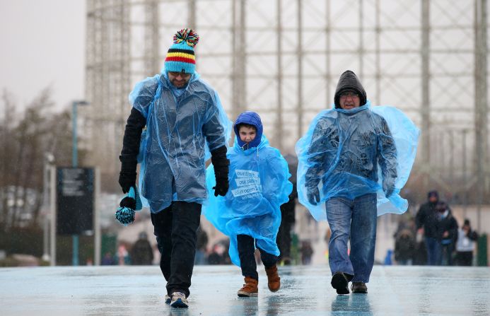 Manchester City supporters make their way to the stadium in wet weather prior to the Premier League match between Manchester City and Leicester City at the Etihad Stadium on February 6, 2016 in Manchester, England.