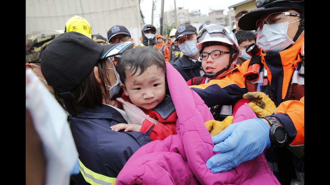 A boy is rescued from a collapsed building in Tainan on February 6. More than 200 people were rescued from damaged structures, many from a 16-story residential building that collapsed in Tainan, officials told CNN.