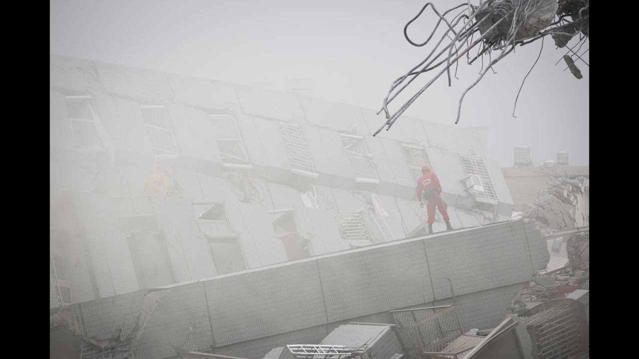 Heavy smoke comes out from a collapsed building as rescue personnel search for survivors in Tainan.