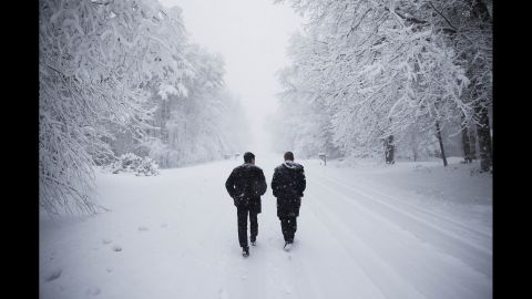 Dave Chiokadze, left, and James Radcliffe, volunteers for Republican presidential candidate Donald Trump, walk through the snow knocking on doors in search of Trump supporters in Londonderry, New Hampshire, on February 5.