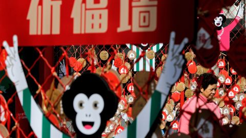 A woman in Beijing walks past New Year wish cards on Thursday, February 4.