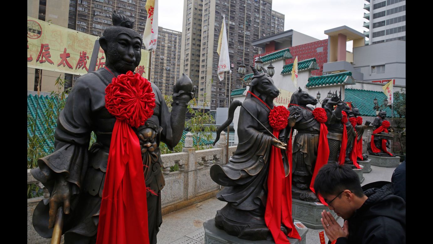 A visitor prays in front of a monkey statue at the Wong Tai Sin Temple in Hong Kong on Wednesday, February 3.