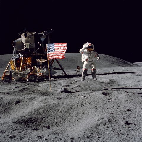 Young leaps from the surface of the moon as he salutes the U.S. flag.