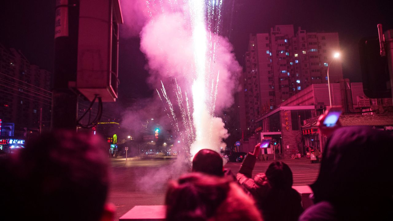 People watch fireworks on a street in Beijing on February 7. 