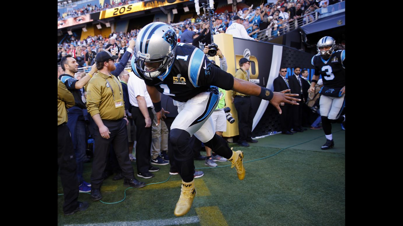Newton and the Panthers run onto the field before the game.