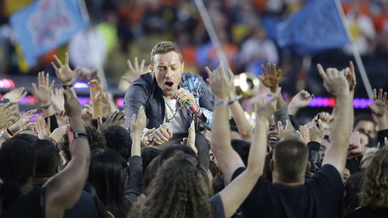 Coldplay frontman Chris Martin greets fans during his band's performance.
