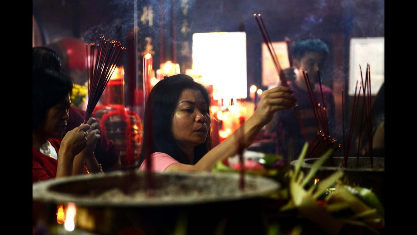 A woman offers prayers at the Vihara Dharmayana Temple in Kuta, Indonesia, on February 8.