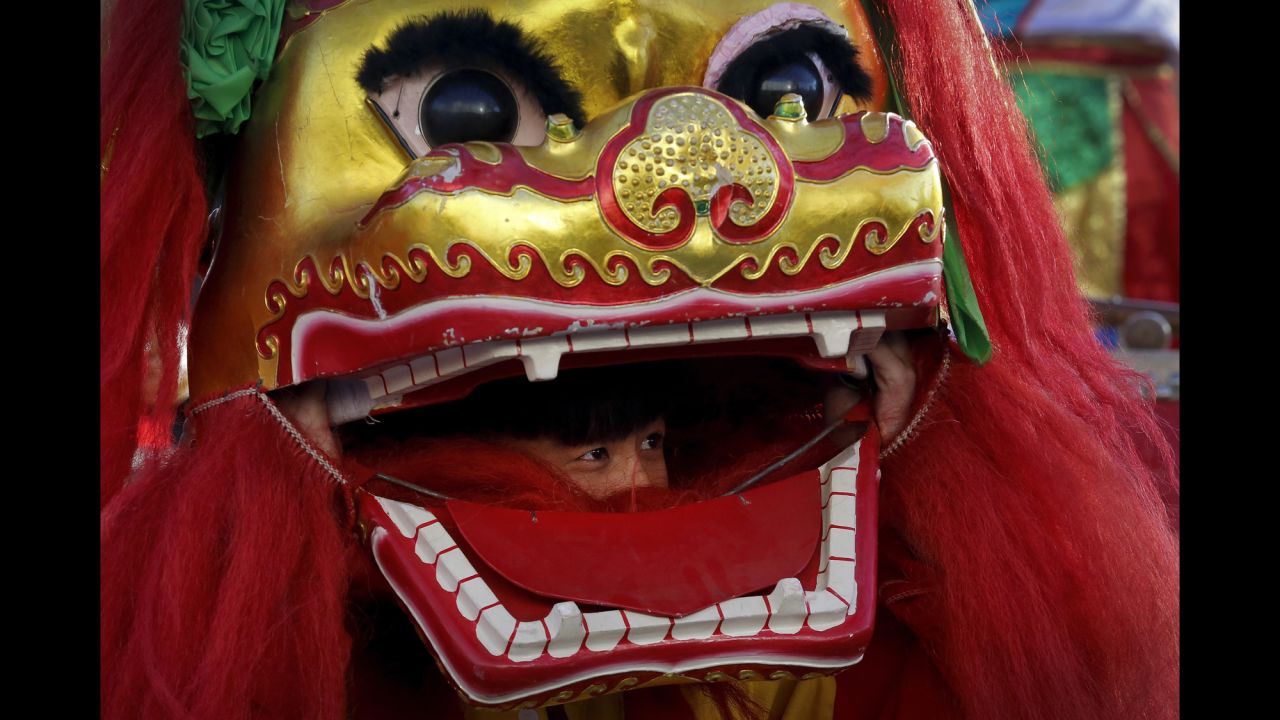 A performer looks out from the mouth of a lion head at Ditan Park in Beijing on February 8.