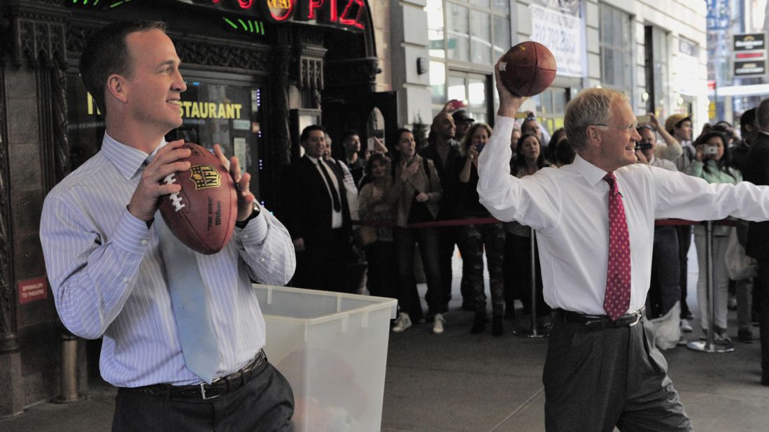 Manning and talk-show host David Letterman throw footballs at New York City cabs during a "Late Show" taping in 2014.