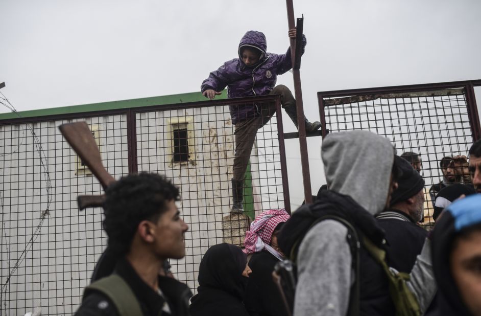 A child tries to climb over a fence near the Turkish border as Syrians fleeing the northern city of Aleppo wait on February 6.