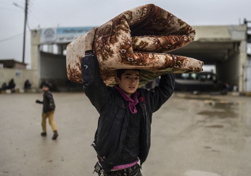 A young refugee carrying belongings arrives at the Turkish border on February 6.