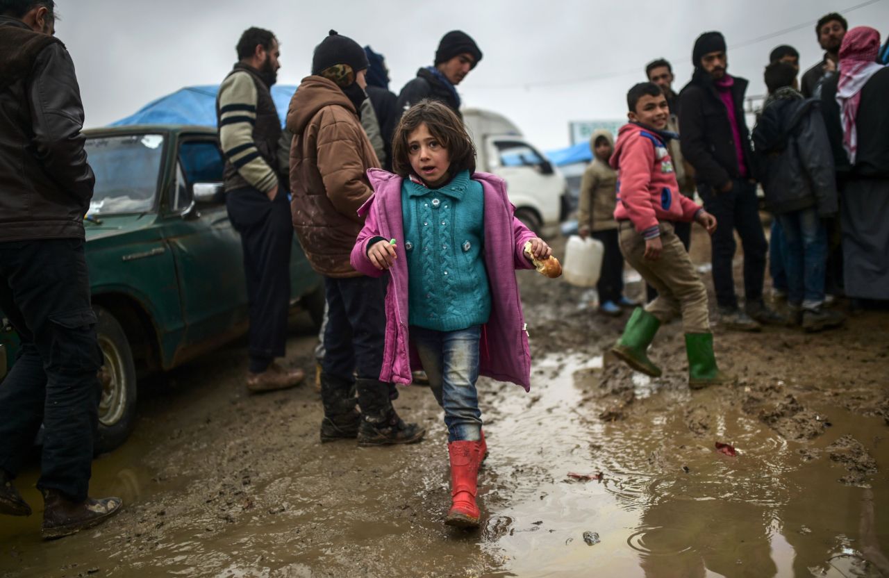 Refugees brave the cold and rain as they arrive at the Turkish border on February 6.