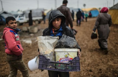 A child carries his belongings as Syrian refugees arrive at the Turkish border on February 6.