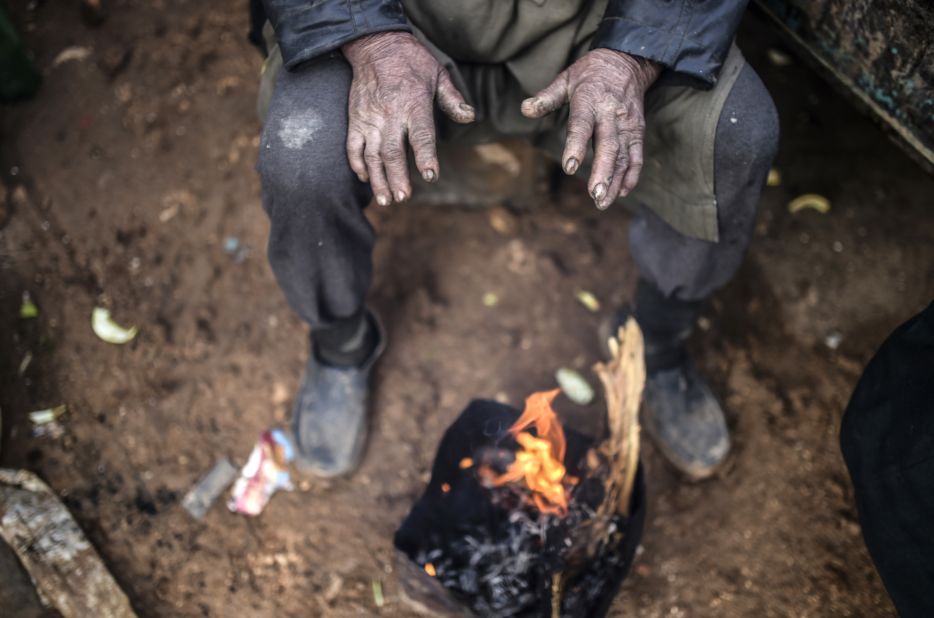 A refugee warms himself at a bonfire near the Turkish border on February 6.