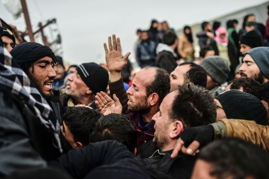 Refugees push each other as they wait for tents near the Turkish border on February 6.