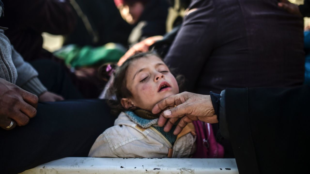 Syrian refugees wait at a border crossing into Turkey.