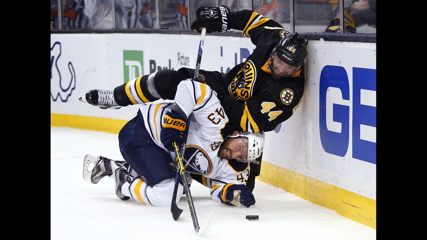Boston's Dennis Seidenberg falls on Buffalo's Daniel Catenacci during an NHL game in Boston on Saturday, February 6.