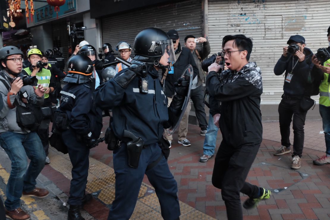 Riot police and a protester scuffle in a street in Mong Kok on February 9.