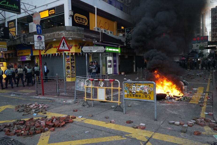 Objects are set on fire as bricks lay scattered about at an intersection in Mong Kok, a busy shopping district.