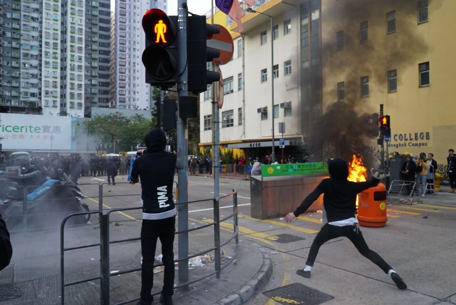 A protester hurls a brick at riot police during clashes in Mong Kok early February 9.