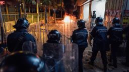 Rioters set fires in Mong Kok as riot police put up shields on February 9 in Hong Kong.