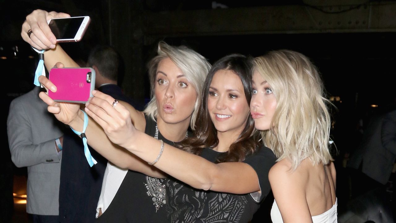 Actress Nina Dobrev, center, takes selfies with hairstylist Riawna Capri, left, and actress Julianne Hough at a party in San Francisco on Saturday, February 6.