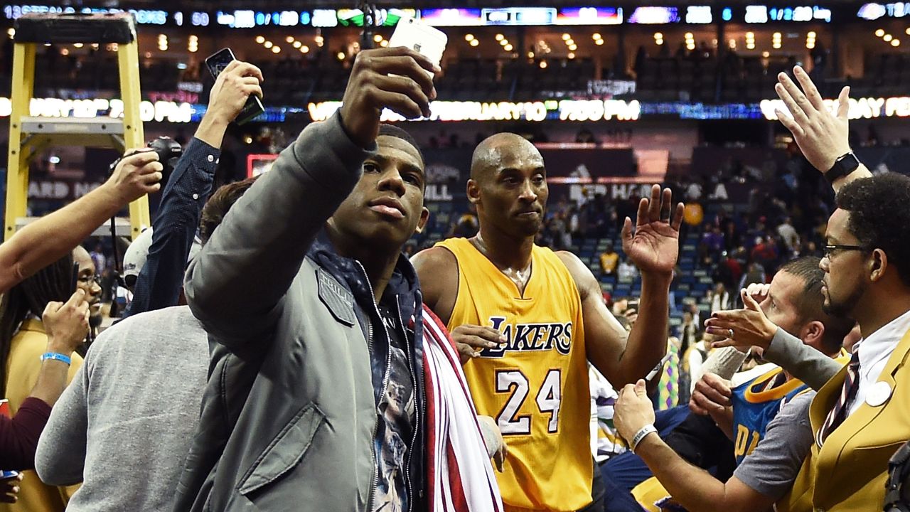 A fan snaps a photo with basketball star Kobe Bryant after an NBA game in New Orleans on Thursday, February 4. 