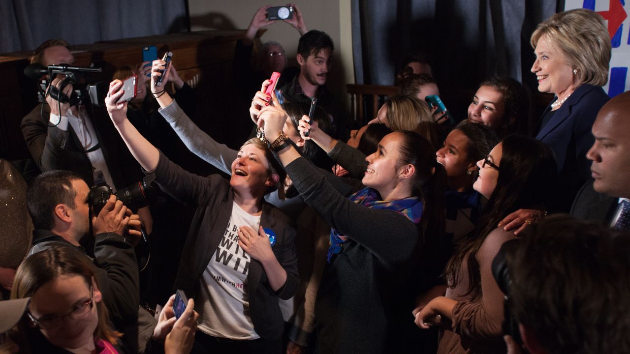 People take selfies with Democratic presidential candidate Hillary Clinton, far right, at a debate-watching party in Durham, New Hampshire, on Thursday, February 4.