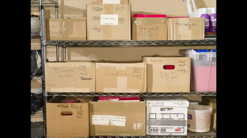 Boxes of wigs sit on shelves.