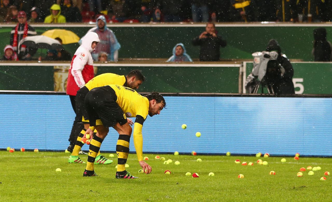 Borussia Dortmund players turned ball boys in the first half of their German Cup quarterfinal clash against Stuttgart Tuesday, after hundreds of fans threw tennis balls onto the pitch in protest at high ticket prices.