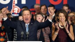 With his wife Karen at his side Republican presidential candidate Ohio Gov. John Kasich cheers with supporters Tuesday, Feb. 9, 2016, in Concord, N.H., at his primary night rally. (AP Photo/Jim Cole)
