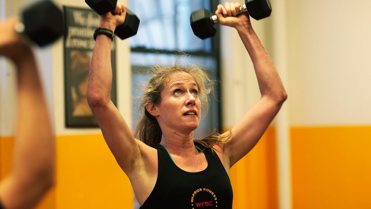 NEW YORK - MARCH 17:  A woman lifts dumbells during a workout at Warrior Fitness Boot Camp gym March 17, 2009 in the Midtown neighborhood of New York City.  Two former Marine sergeants, one an Iraq War veteran, began the boot camp-style training gym in 2008, bringing the exercises and drills they did as young Marines at the notorious Marine Corps Recruit Depot at Parris Island to more sedentary New Yorkers.  Most customers do the vigorous, team-style workouts 3-4 times a week, with workouts beginning before sunrise at 5:30 am.  (Photo by Chris Hondros/Getty Images)