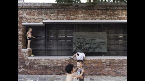 Children play in front of a memorial for Venetian Jews who were deported during World War II.