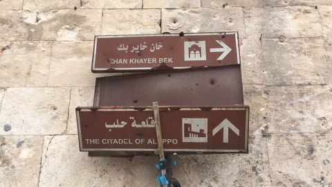 Bullet holes puncture street signs meant to help tourists find their way around Aleppo's old town.