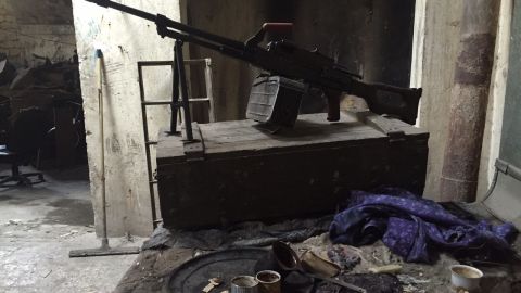 A gun and teacups sit amid the rubble in a fighting position held by Syrian regime forces.