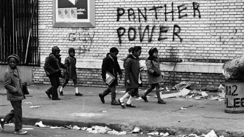Children walk by Panther Power graffiti. The group saw themselves as the vanguard of a worldwide revolution, a revolution that had sparked uprisings in places like Vietnam and Cuba in the 1960s.