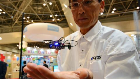 An employee of Japan's toy maker Kyosho displays the world's smallest drone "Quatrox."