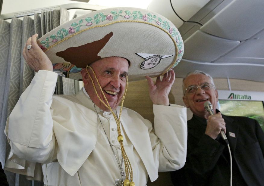 Pope Francis tries on a traditional sombrero he received as a gift from a Mexican journalist on Friday, February 12, 2016, aboard a flight from Rome to Havana, Cuba. The voyage kicked off his weeklong trip to Mexico. With his penchant for crowd-pleasing and spontaneous acts of compassion, Pope Francis has earned high praise from fellow Catholics and others since he succeeded Pope Benedict XVI in March 2013.
