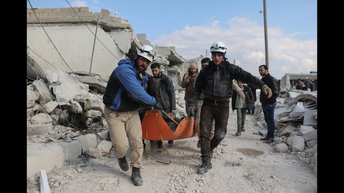 Members of the "White Helmets" civil defense volunteers carry the body of a man killed in a Russian airstrike in Andan town in the countryside north of of Aleppo.
