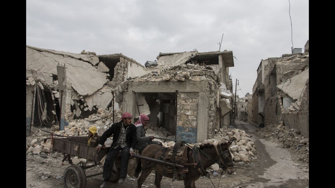 Two men and their donkey navigate the bombed alleyways of Almarja district in eastern Aleppo.