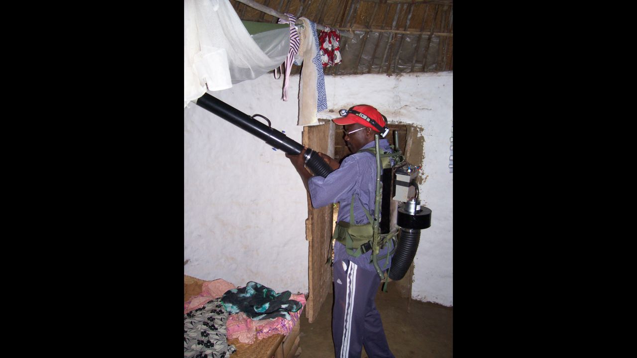 Research assistant Alassane aspirates mosquitoes inside a villager's home. After feeding on humans during the night, the mosquitoes often hide in bedding and along ceiling rafters. 