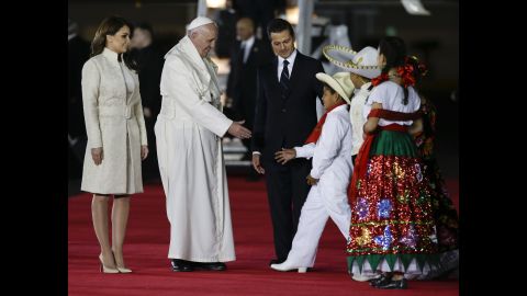 Pope Francis greets youth dressed in traditional outfits as he's escorted by Pena Nieto and first lady Angelica Rivera on Friday, February 12. 